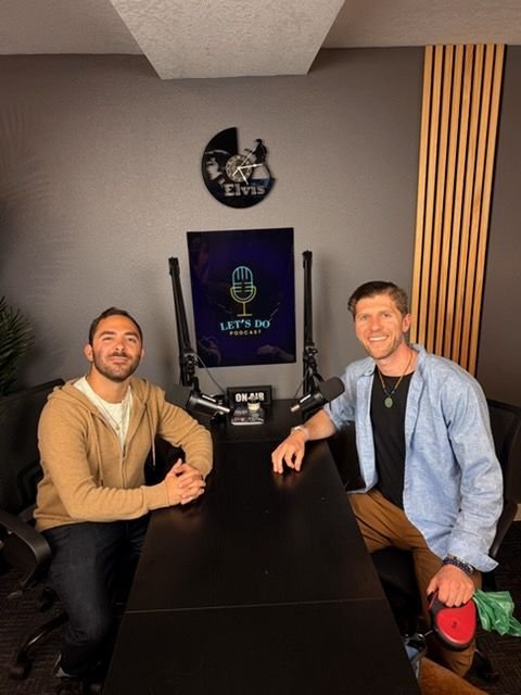 Julian at the podcast table recording with a guest
